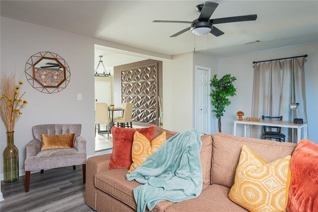 living area with a ceiling fan, visible vents, and wood finished floors