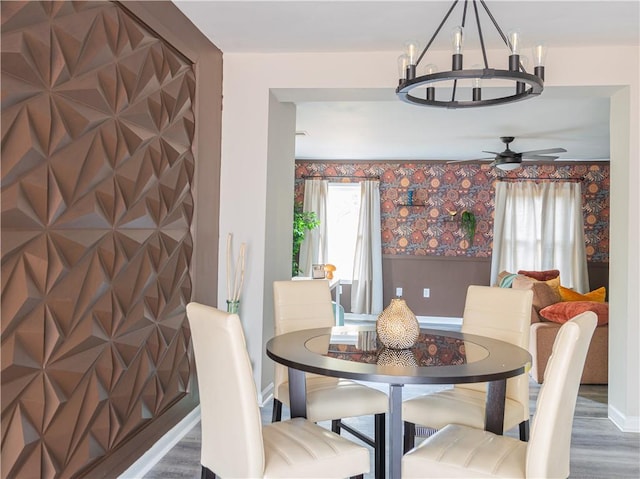 dining room featuring a chandelier, dark wood-style flooring, baseboards, and wallpapered walls