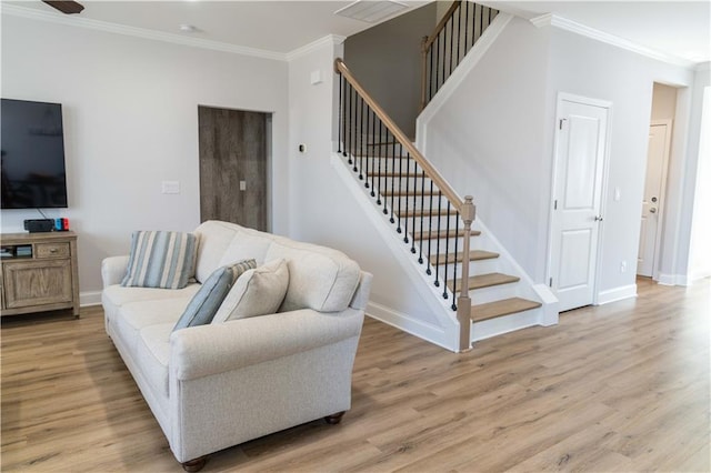 living area featuring stairway, baseboards, ornamental molding, and light wood finished floors