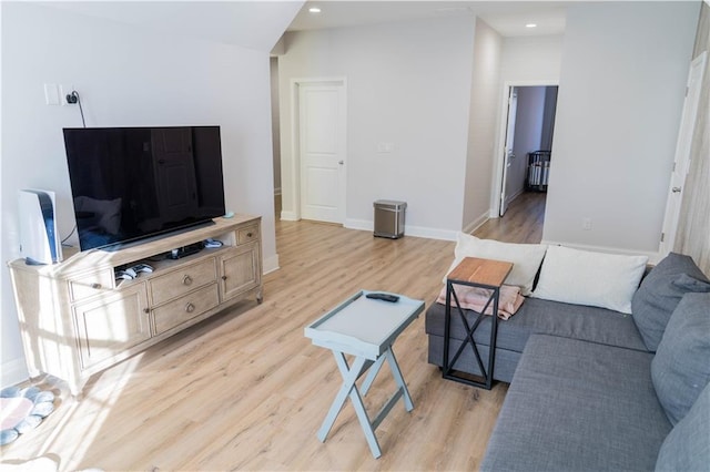 living room featuring light wood-style flooring, recessed lighting, and baseboards