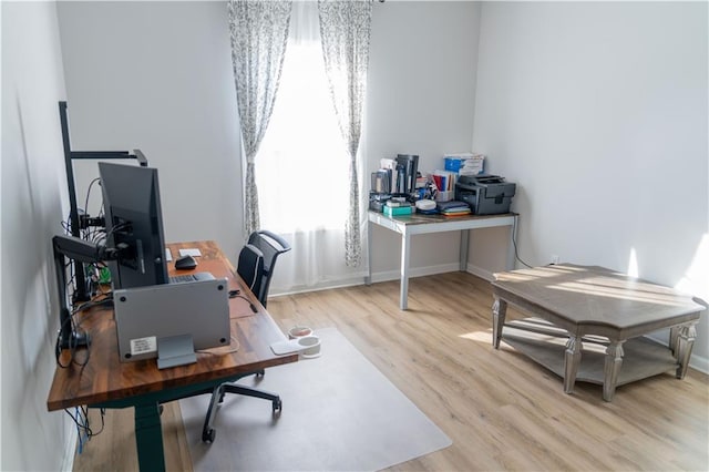 office with baseboards and light wood-style flooring