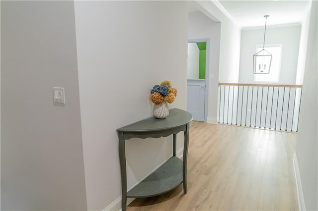 hallway with baseboards, wood finished floors, and ornamental molding