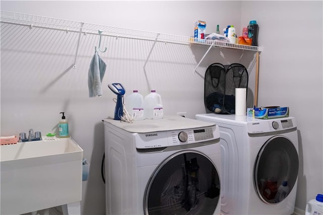 laundry area featuring laundry area, independent washer and dryer, and a sink