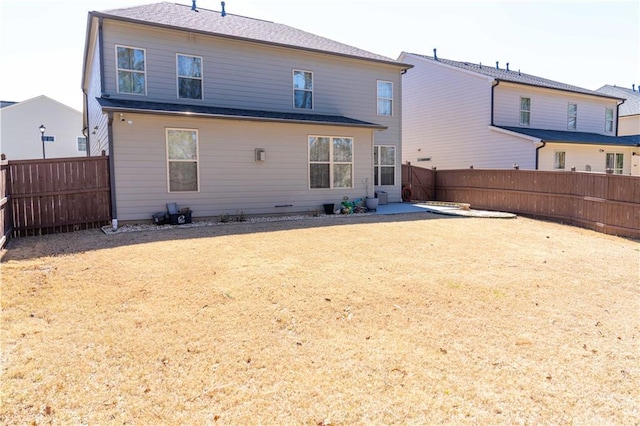 rear view of property featuring a patio and a fenced backyard