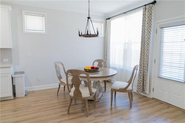 dining space with a healthy amount of sunlight, light wood-style flooring, and an inviting chandelier