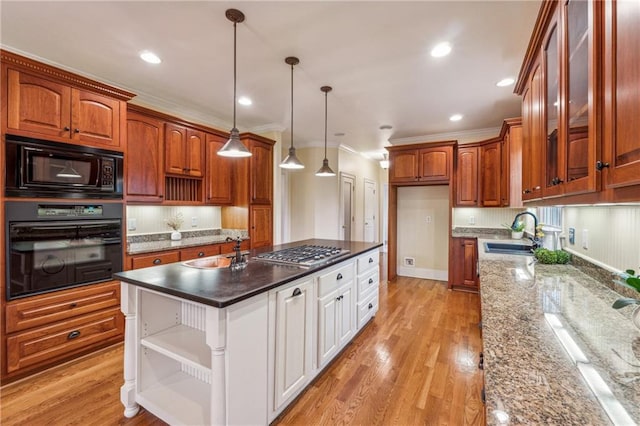 kitchen featuring ornamental molding, sink, black appliances, pendant lighting, and light hardwood / wood-style floors