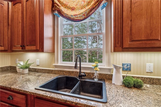 kitchen featuring light stone countertops, plenty of natural light, and sink