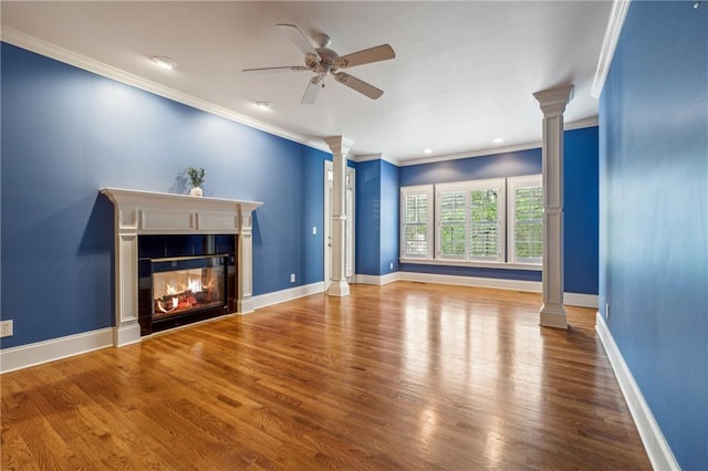 unfurnished living room featuring hardwood / wood-style floors, decorative columns, ceiling fan, and crown molding