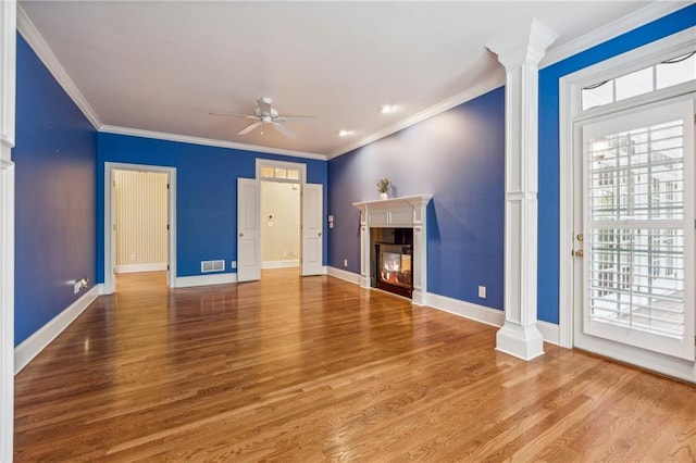 unfurnished living room featuring hardwood / wood-style flooring, ceiling fan, crown molding, and decorative columns