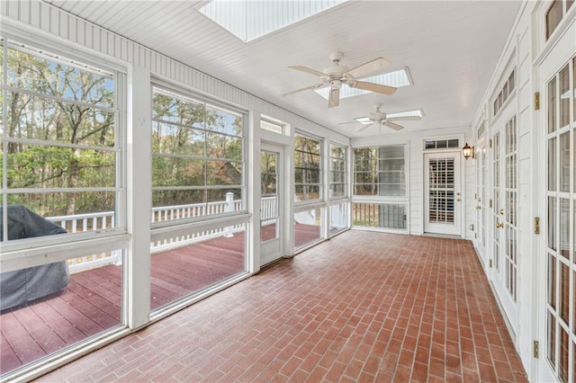 unfurnished sunroom featuring a skylight and ceiling fan