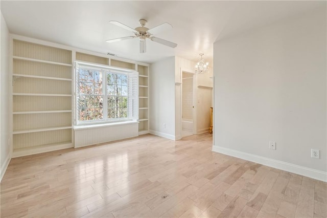 spare room featuring ceiling fan with notable chandelier, light hardwood / wood-style floors, and built in features