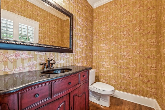 bathroom with hardwood / wood-style floors, vanity, toilet, and ornamental molding