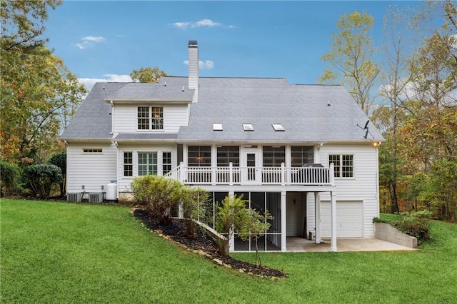 rear view of house featuring cooling unit, a garage, a yard, and a deck