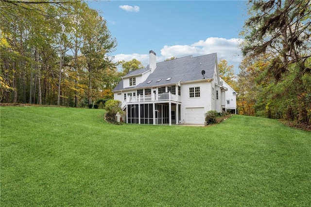 back of property with a yard, a garage, and a sunroom