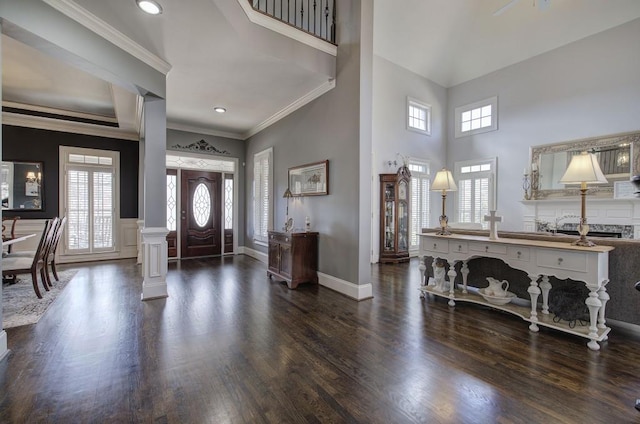 entryway featuring a healthy amount of sunlight, a high ceiling, ornamental molding, and dark wood-type flooring