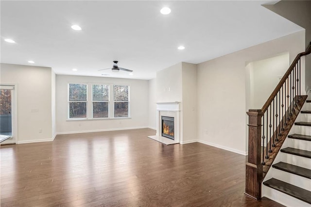 unfurnished living room featuring ceiling fan and dark hardwood / wood-style flooring