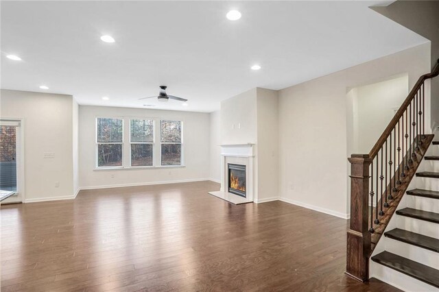 unfurnished living room with dark hardwood / wood-style flooring, sink, and ceiling fan