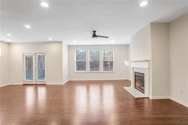 unfurnished living room featuring dark hardwood / wood-style flooring and ceiling fan