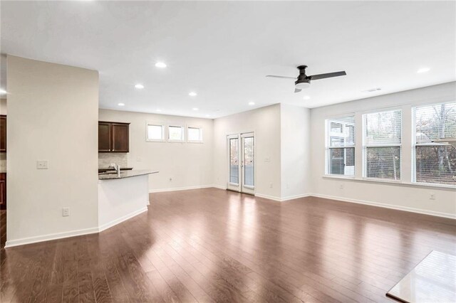 unfurnished living room with ceiling fan and dark hardwood / wood-style flooring