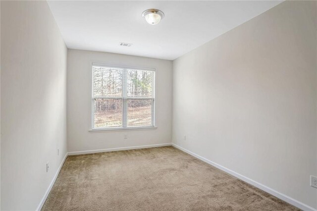 carpeted spare room with a tray ceiling and ceiling fan