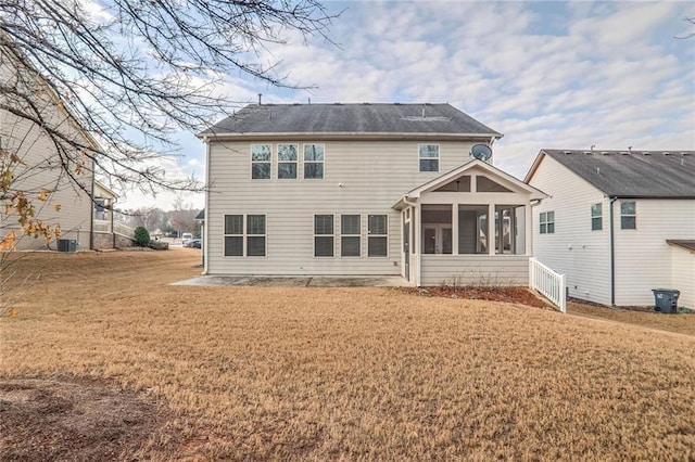 rear view of property with a sunroom and a yard