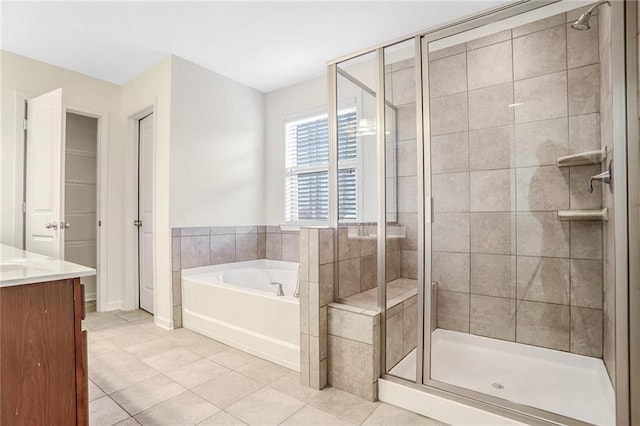 bathroom with tile patterned flooring, vanity, and separate shower and tub