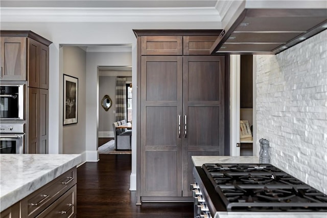 kitchen with dark wood-type flooring, stainless steel appliances, light stone counters, dark brown cabinetry, and exhaust hood