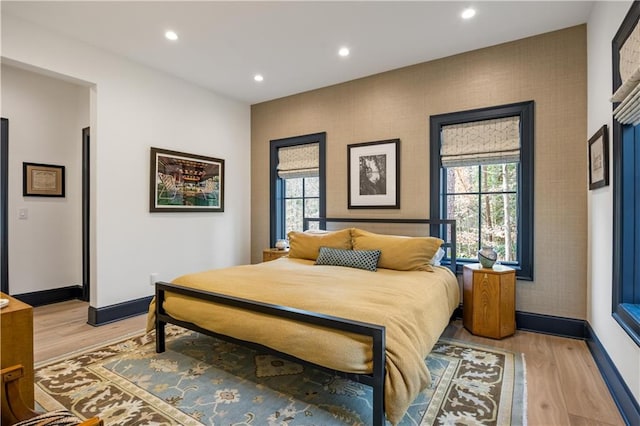 bedroom with multiple windows and light wood-type flooring