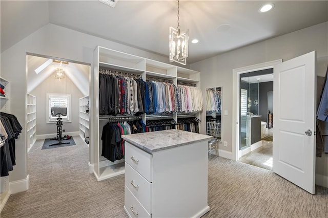 walk in closet featuring an inviting chandelier, vaulted ceiling, and light colored carpet