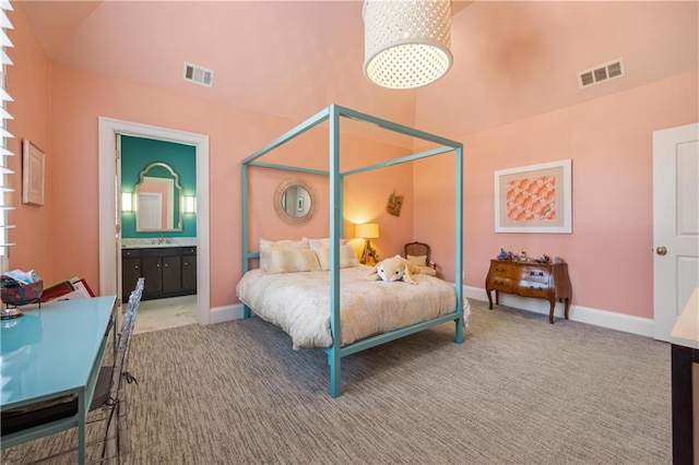 bedroom with connected bathroom, sink, carpet floors, and vaulted ceiling