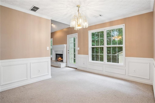 605 Pebble Blvd, Covington, GA 30016 - unfurnished living room with carpet floors, a chandelier, a textured ceiling, a high end fireplace, and a wainscoted wall
