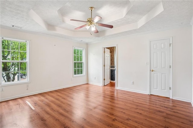 605 Pebble Blvd, Covington, GA 30016 - spare room featuring a textured ceiling, a raised ceiling, healthy amount of natural light, wood finished floors, and ornamental molding