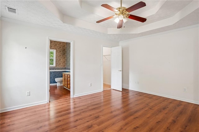 605 Pebble Blvd, Covington, GA 30016 - unfurnished bedroom with a raised ceiling, wood finished floors, a walk in closet, baseboards, and ensuite bathroom