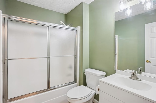 605 Pebble Blvd, Covington, GA 30016 - bathroom featuring toilet, vanity, a textured ceiling, and combined bath / shower with glass door