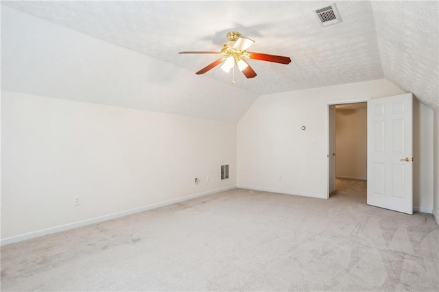 605 Pebble Blvd, Covington, GA 30016 - additional living space with lofted ceiling, light carpet, ceiling fan, baseboards, and a textured ceiling