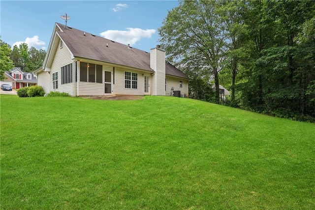 605 Pebble Blvd, Covington, GA 30016 - rear view of property featuring a chimney, a yard, cooling unit, and a shingled roof