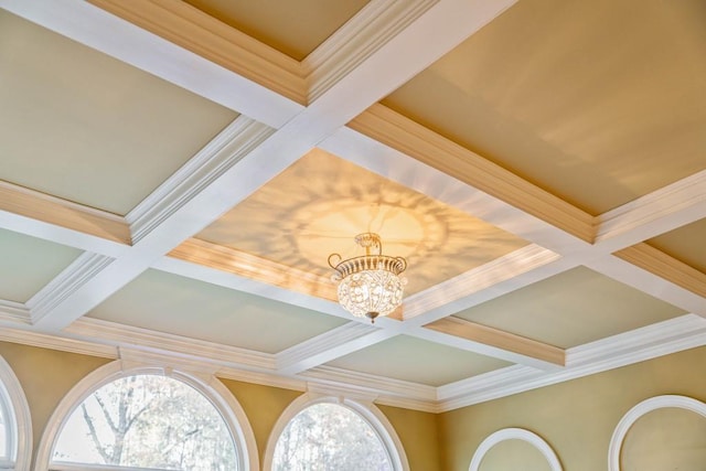 interior details with beam ceiling, crown molding, coffered ceiling, and an inviting chandelier