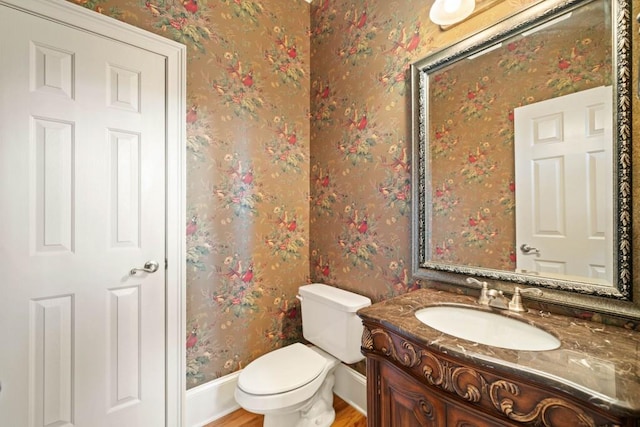 bathroom with hardwood / wood-style floors, vanity, and toilet