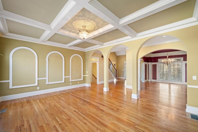 spare room featuring hardwood / wood-style flooring, coffered ceiling, and a notable chandelier