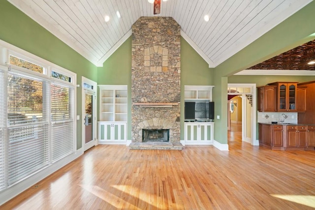 unfurnished living room featuring light wood-type flooring, high vaulted ceiling, wooden ceiling, and a stone fireplace