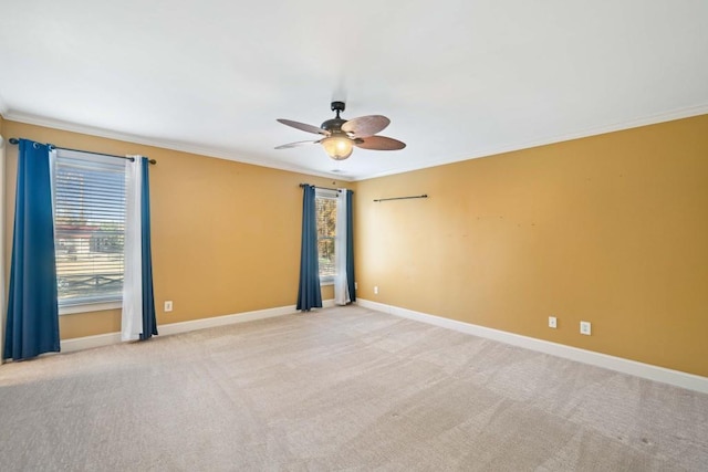 carpeted empty room with ceiling fan and crown molding