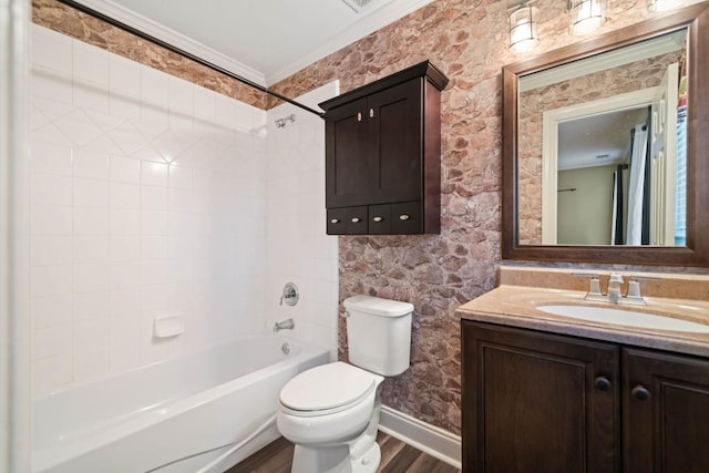 full bathroom featuring hardwood / wood-style floors, vanity, tiled shower / bath, toilet, and ornamental molding