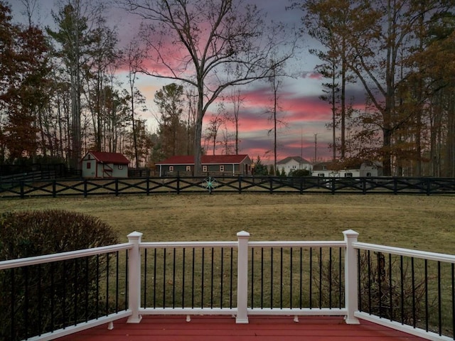 yard at dusk featuring a wooden deck