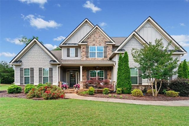 161 Archstone Sq, Mcdonough, GA 30253 - craftsman-style home with board and batten siding, covered porch, a front yard, and stone siding