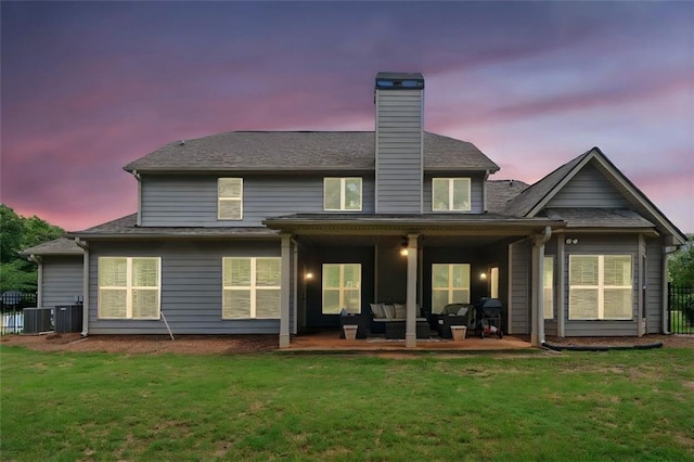 161 Archstone Sq, Mcdonough, GA 30253 - back of property at dusk featuring an outdoor living space, a chimney, a patio, and central AC