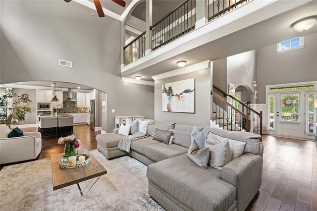 161 Archstone Sq, Mcdonough, GA 30253 - living area with a high ceiling, arched walkways, healthy amount of natural light, ceiling fan, and wood finished floors