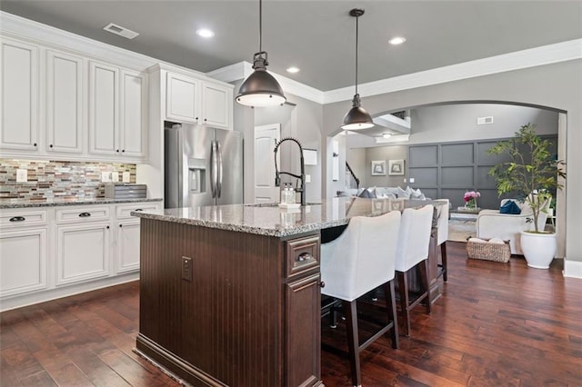161 Archstone Sq, Mcdonough, GA 30253 - kitchen featuring stainless steel fridge, a sink, arched walkways, crown molding, and a kitchen breakfast bar