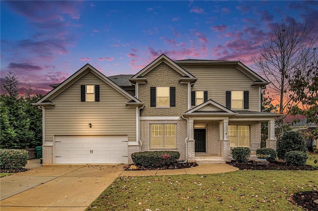 view of front of property with a yard, a garage, and covered porch