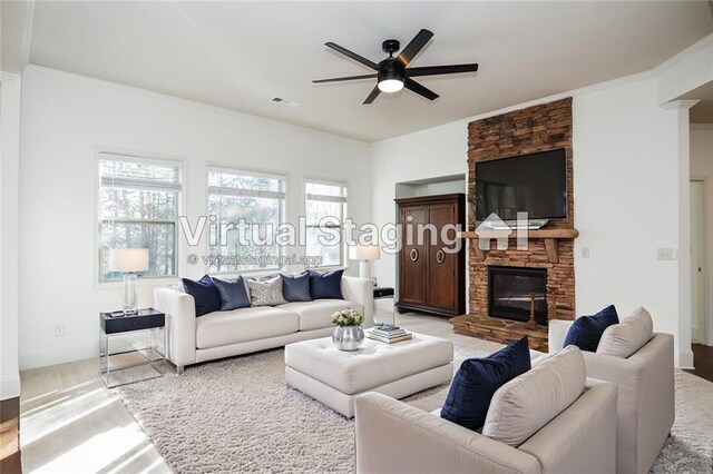 living room featuring a fireplace and ceiling fan