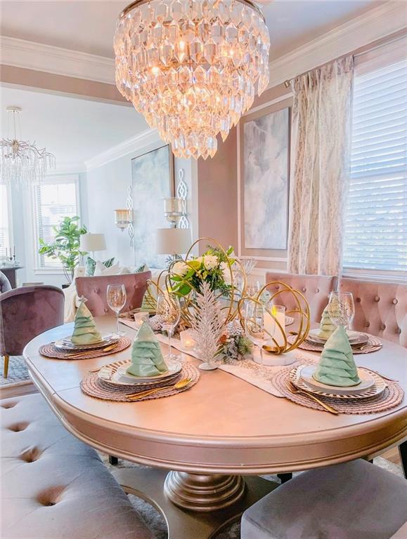 dining room with ornamental molding and an inviting chandelier